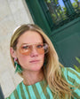 Model wearing bird embroidered statements earrings against city background