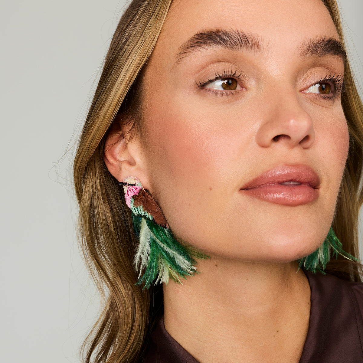 Model wearing bird embroidered statements earrings against a white background