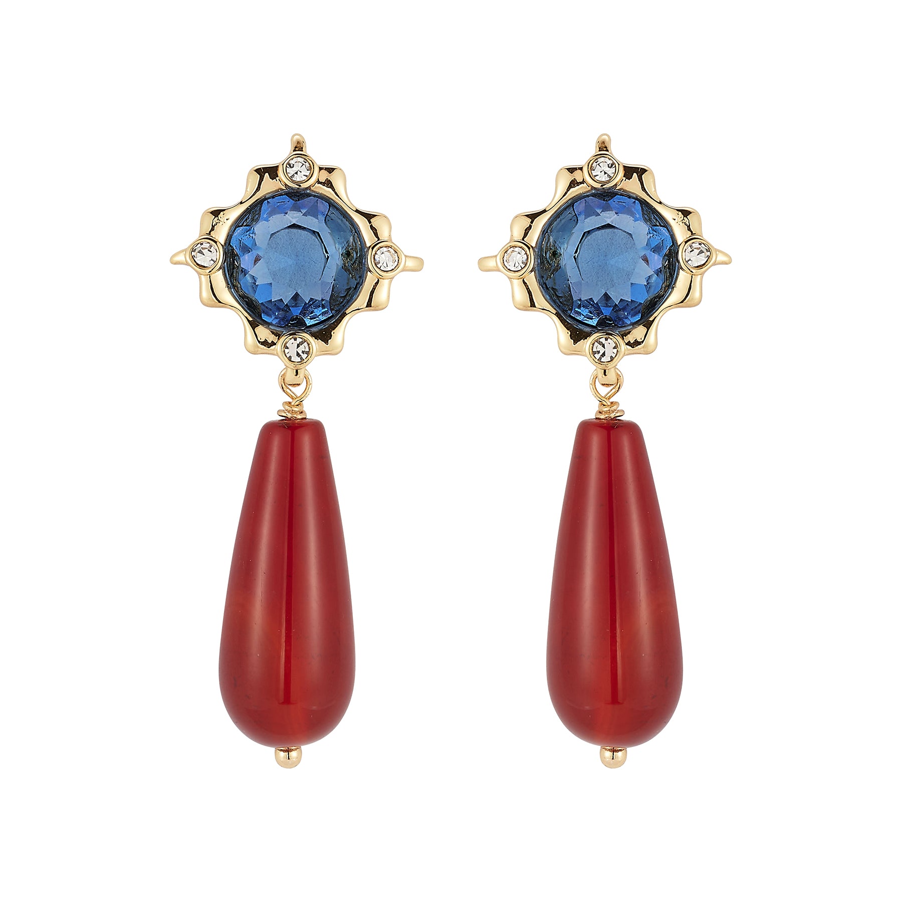A pair of gold drop earrings featuring a faceted blue gemstone in a starburst setting with small clear accent stones, and a long teardrop-shaped red bead dangling below.