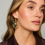 Model wearing chandelier style drop earrings with semi precious stones and gemstones against a whit background