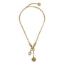 A gold chain necklace with a lobster clasp, featuring two hanging charms: a small oval white stone charm and a larger circular sunburst-patterned gold charm, displayed on a clean white background.