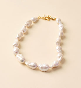 White Pearl Strand Necklace on Tan Background