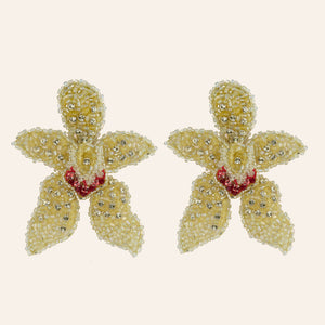 Yellow, Silver, and Pink Bead and Crystal Statement Flower Earrings on Tan Background