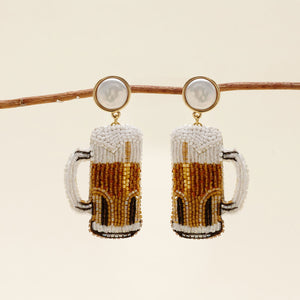 Yellow, Brown, and White Beaded Beer Drop Earrings with Freshwater Pearl Topper on Staged on Branch with Tan Background