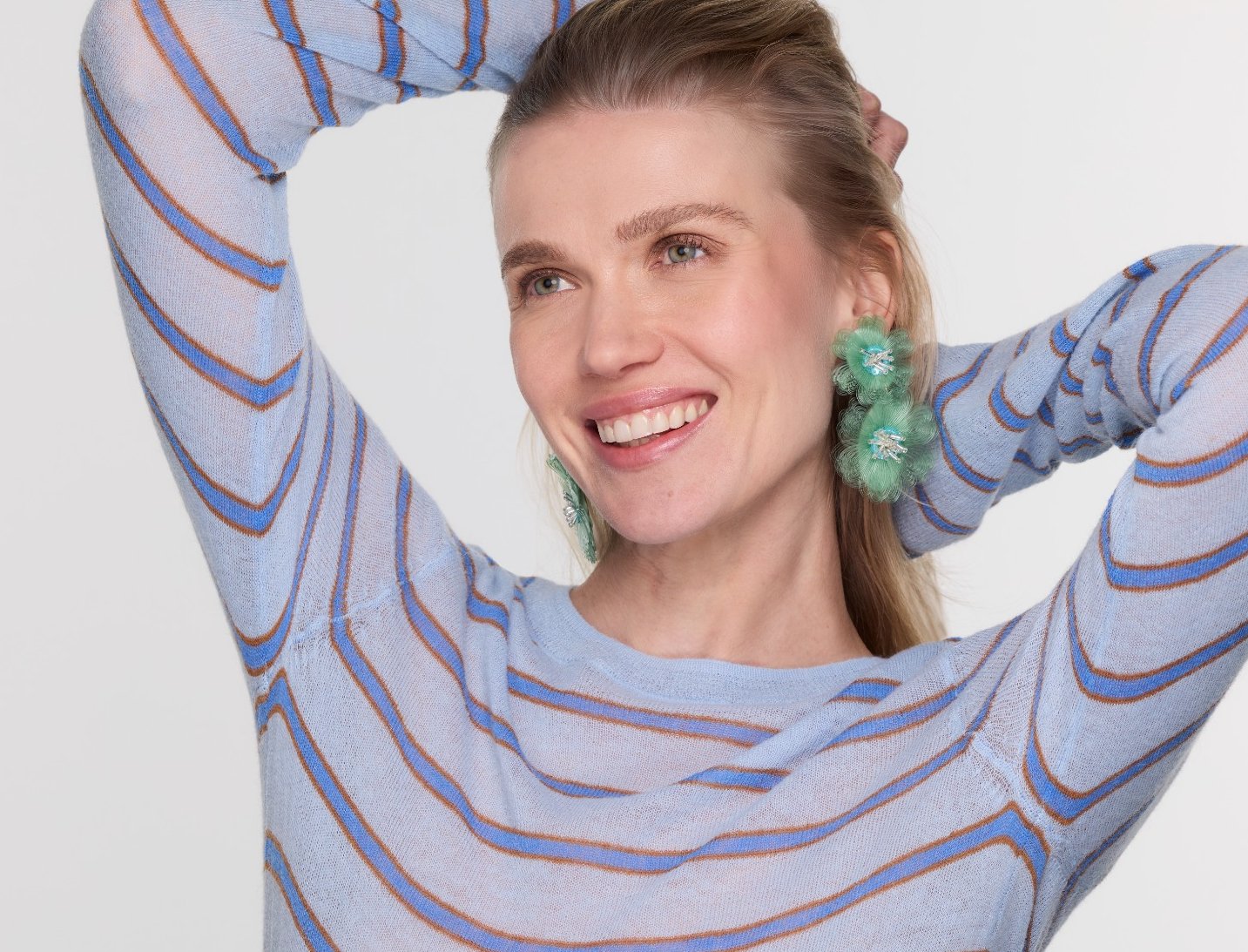 Woman wearing a blue and gray striped outfit with a plain background