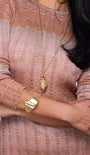 Gold bracelet cuff on model's wrist