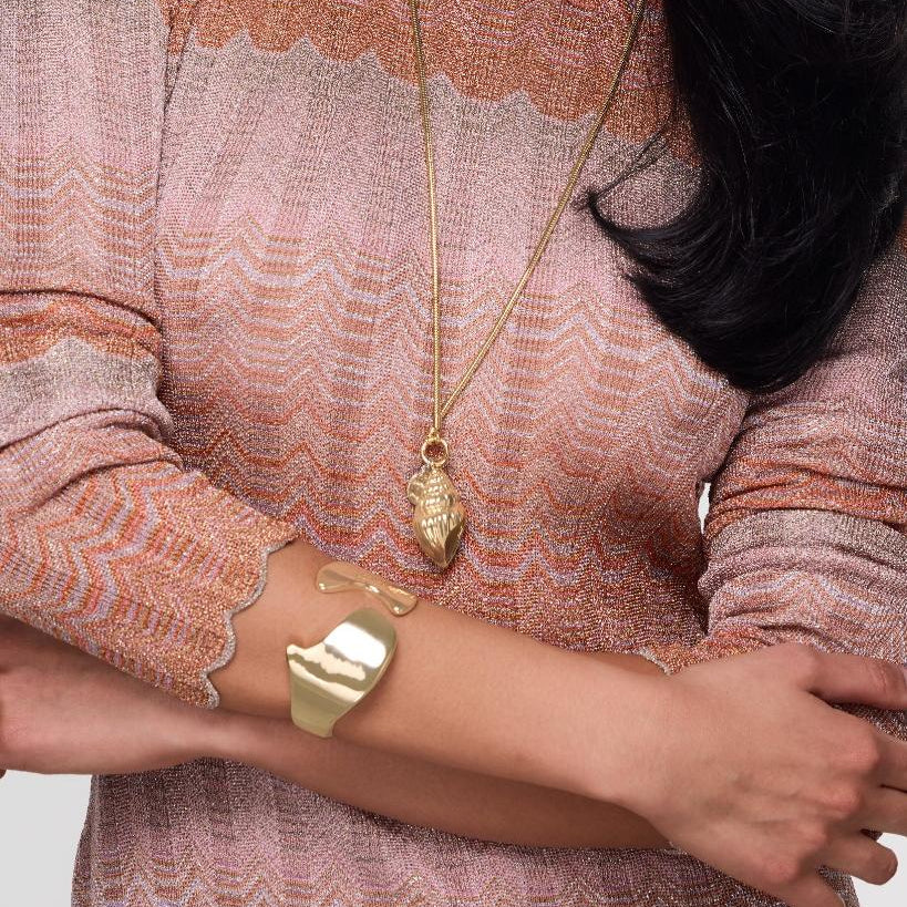 Gold bracelet cuff on model's wrist