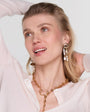 Woman wearing gold jewelry against a light background