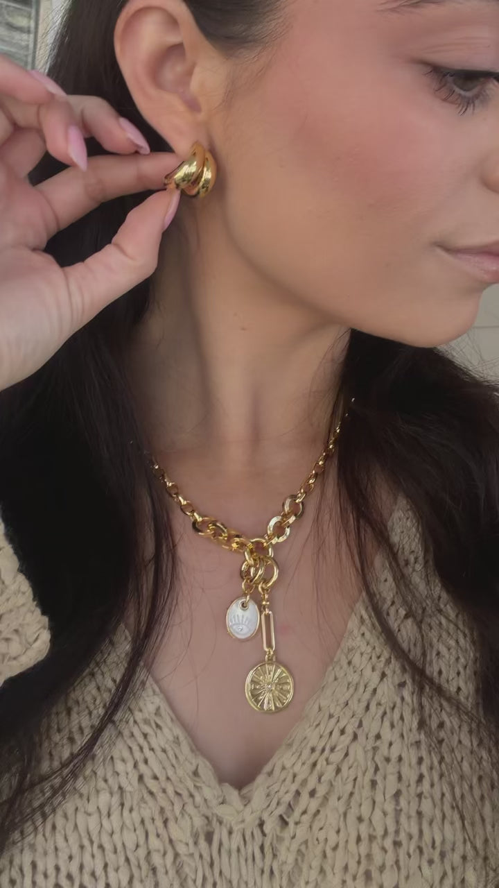 Video of model wearing gold chain necklace and gold hoop earrings