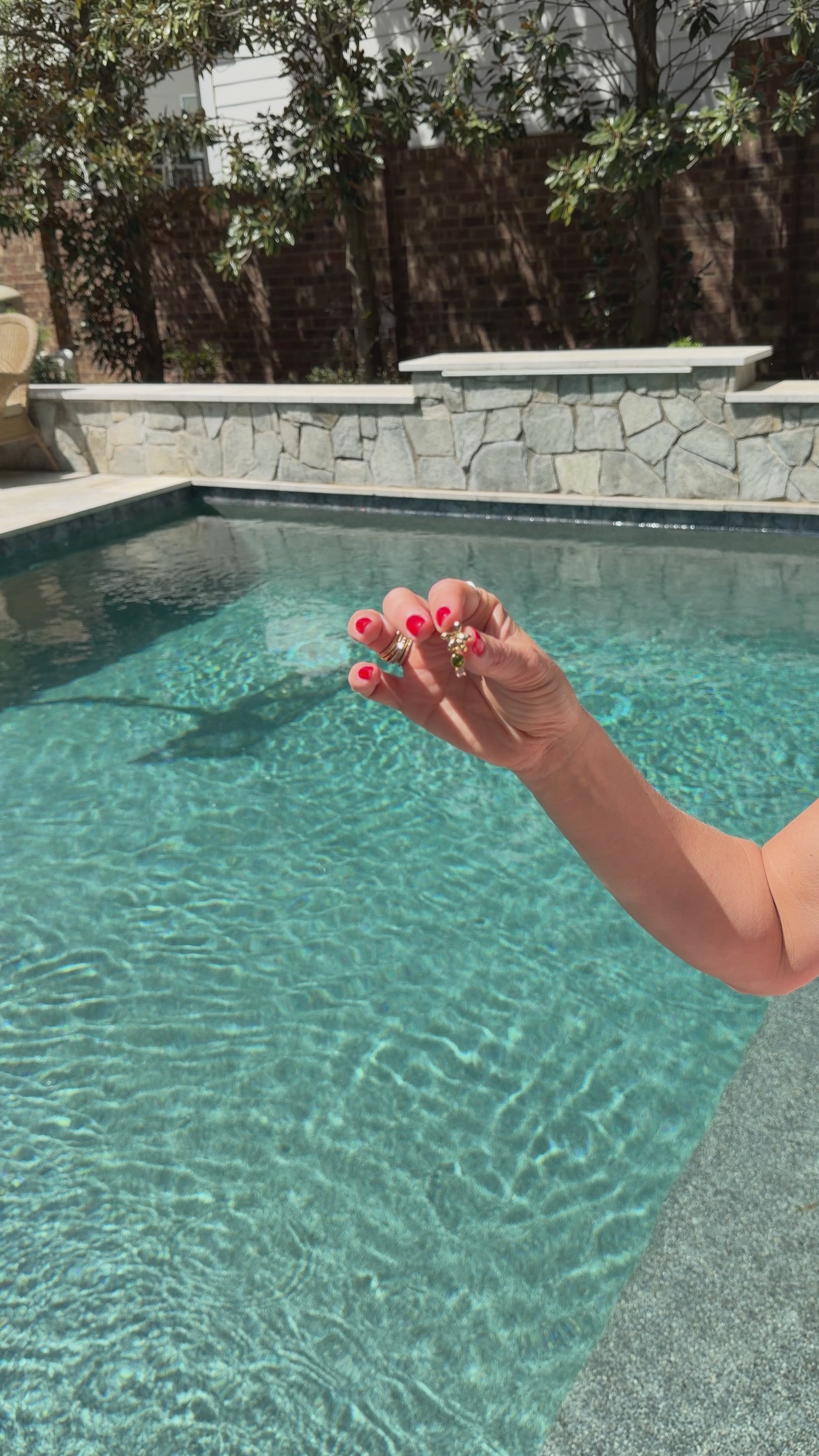 Model next to a pool explaining the significance behind a palm tree shaped earring stud