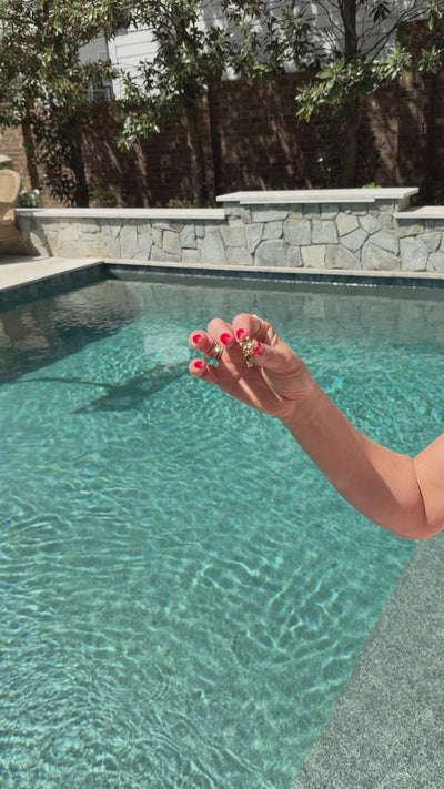 Model next to a pool explaining the significance behind a palm tree shaped earring stud