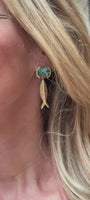 Model wearing blue glass stone earring with fish shaped gold and crystal drop on ear