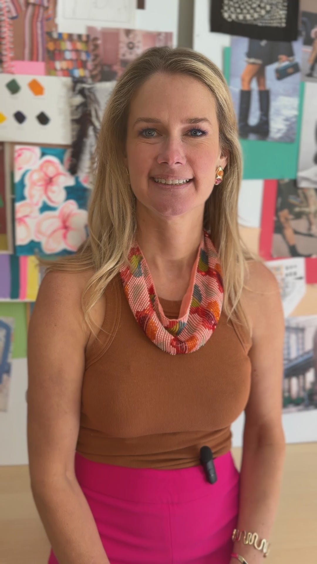 Model explaining the Ysabel Scarf Necklace, a beaded and hand embroidered scarf necklace while wearing a brown top and pink pants