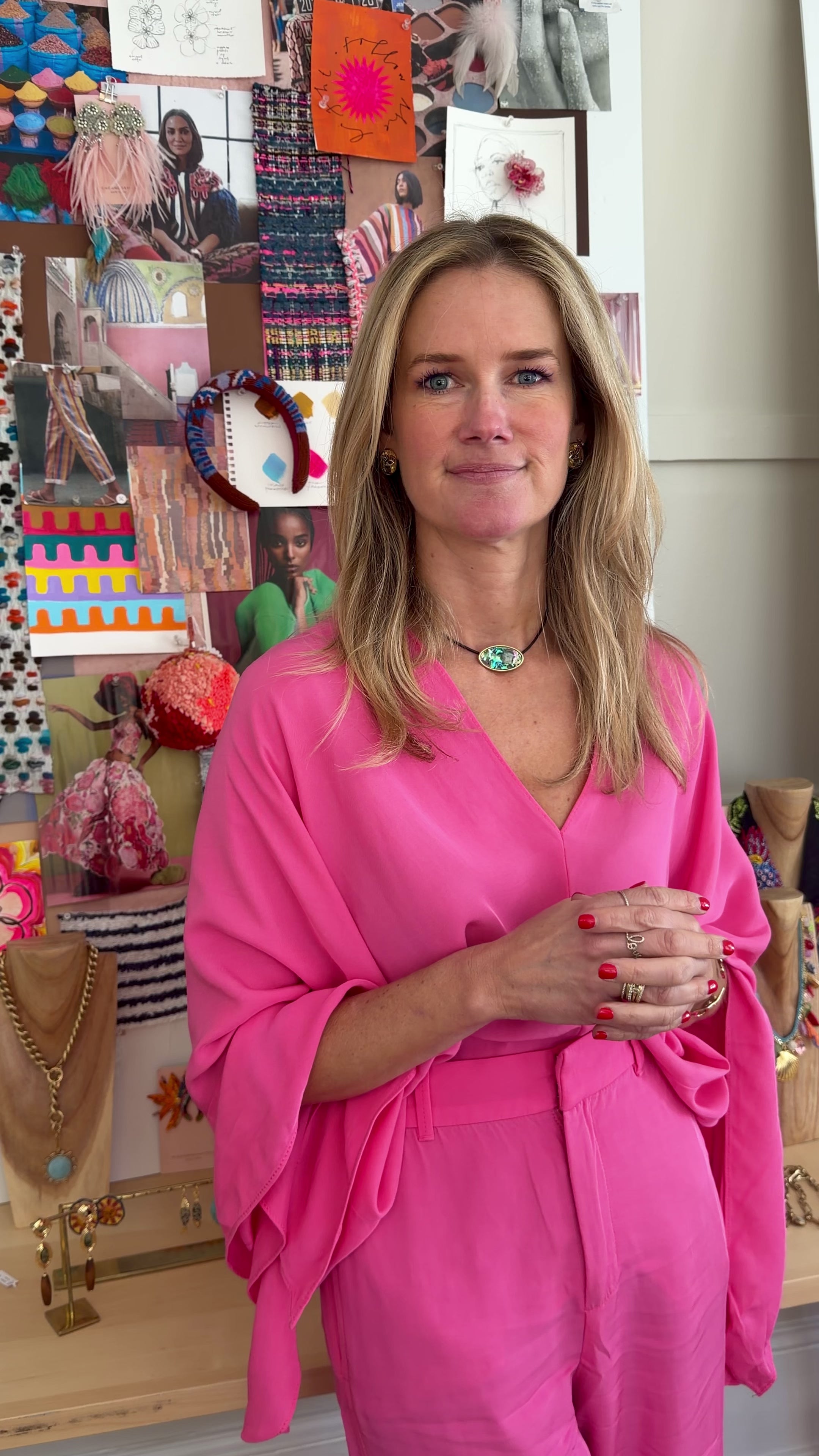 Model wearing pink long sleeve top and pants explaining green mother of pearl choker necklace