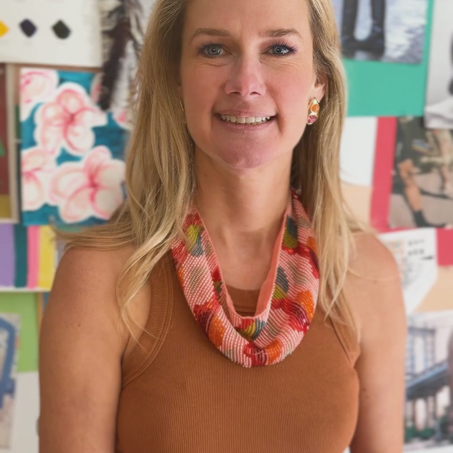Model explaining the Ysabel Scarf Necklace, a beaded and hand embroidered scarf necklace while wearing a brown top and pink pants