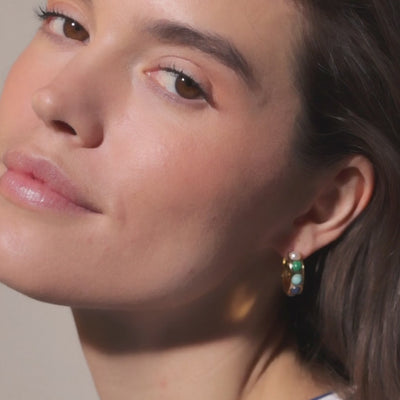 Model wearing semi precious stone and gold huggie hoop. 