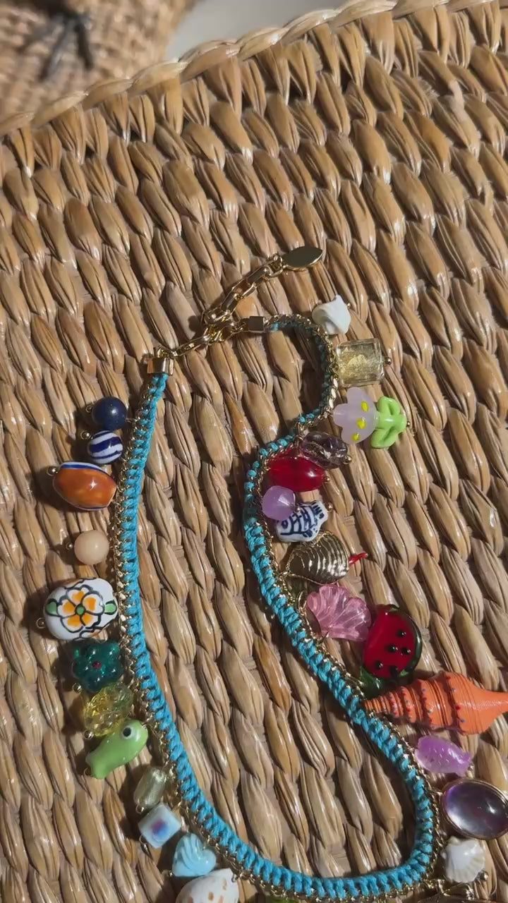 Turquoise necklace with shells and semi precious stones laid down on a wicker table