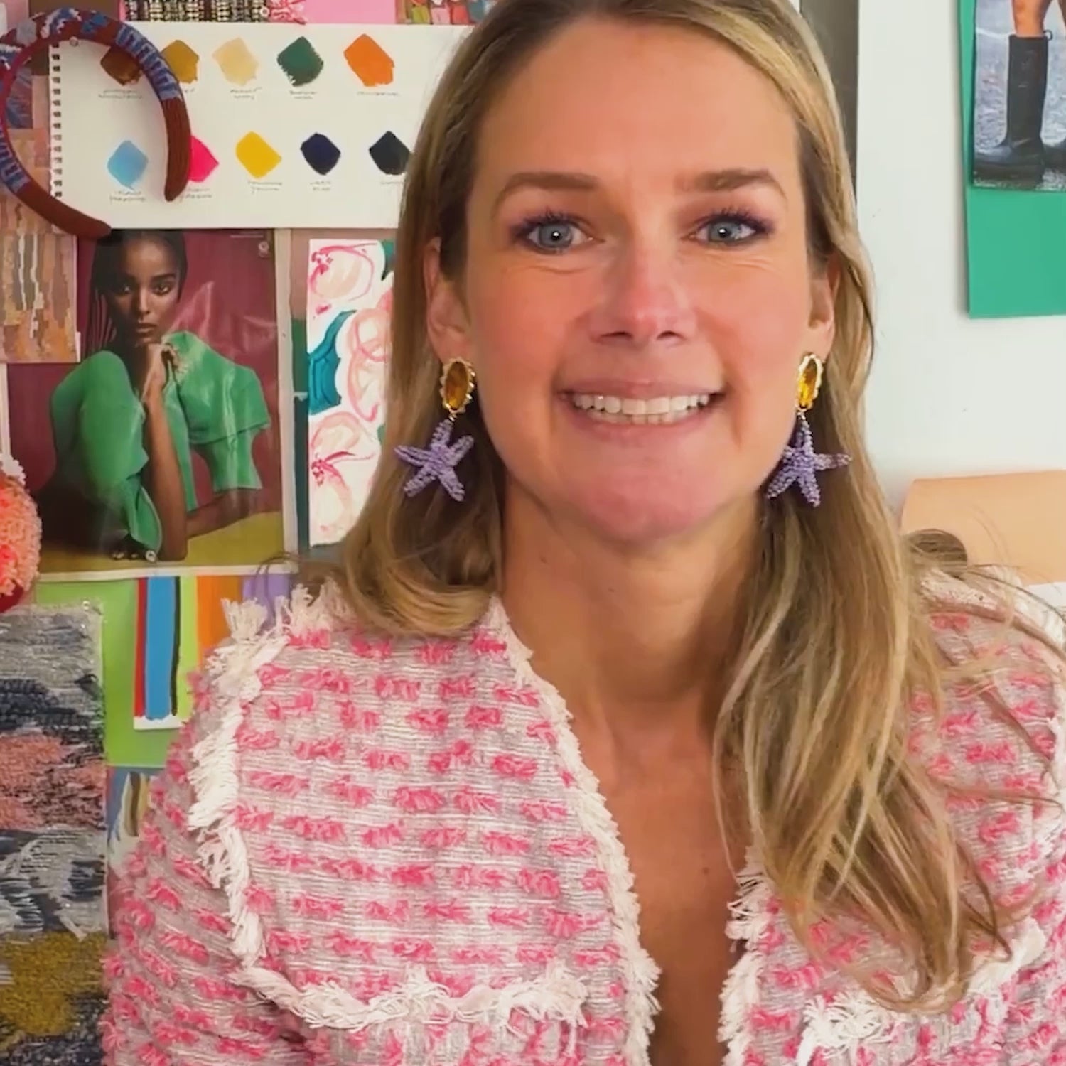 Model wearing pink woven jacket while explaining the Marea Earrings, a purple and orange embroidered drop earring