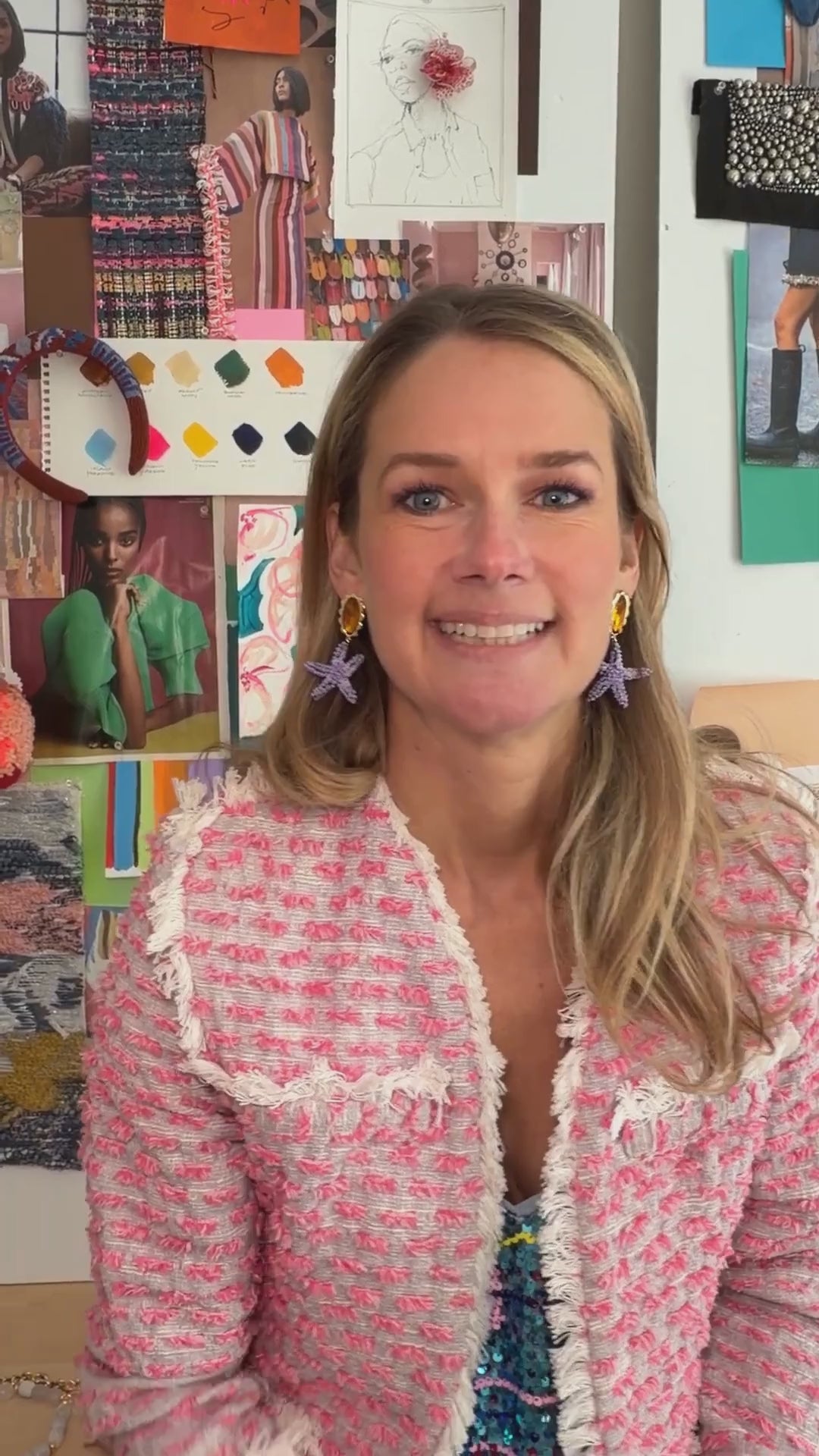 Model wearing pink woven jacket while explaining the Marea Earrings, a purple and orange embroidered drop earring