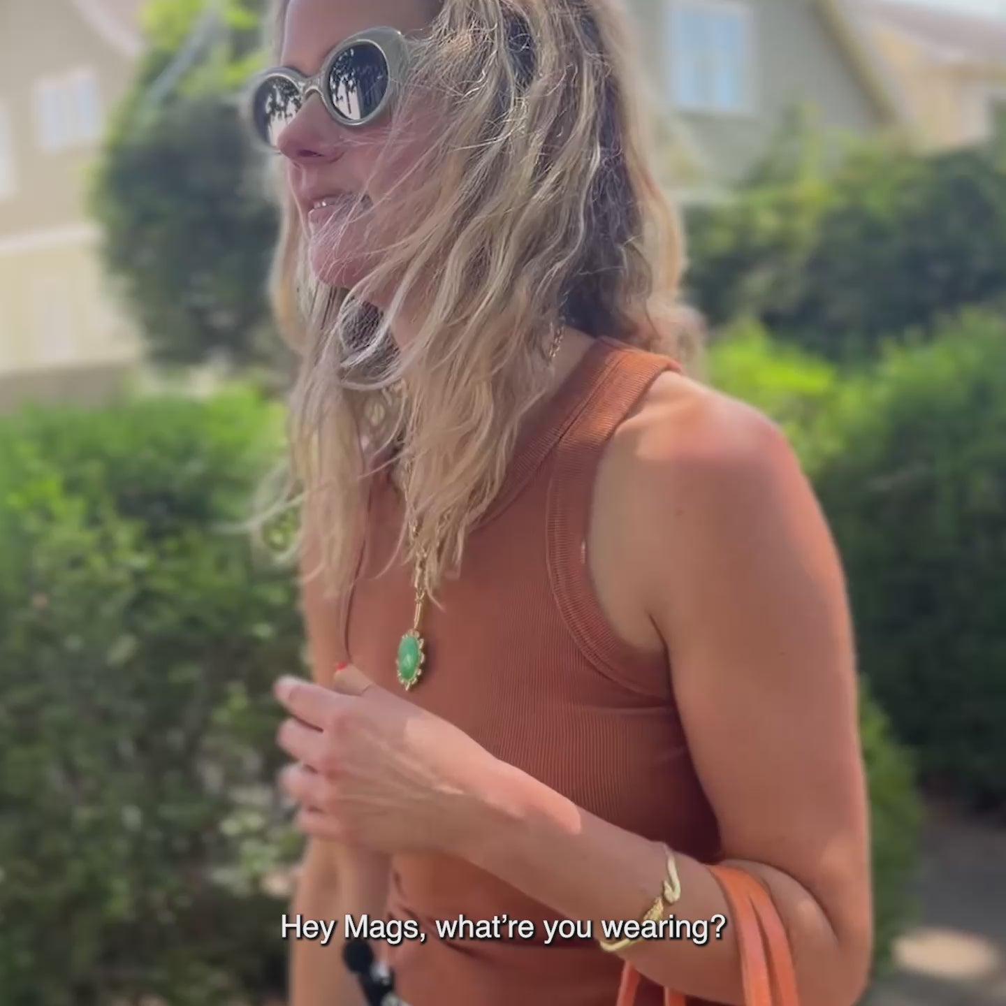 Model wearing the green and gold chain link odyssey necklace while walking down the street