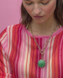 Model wearing Odyssey Green Chain Link Necklace wearing a pink striped shirt