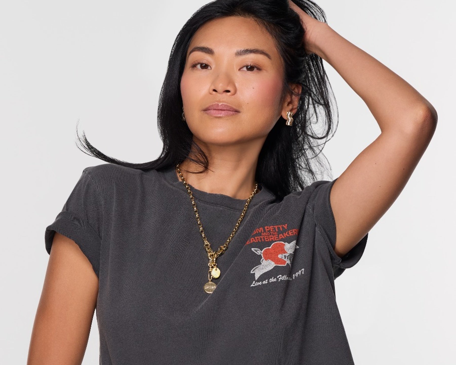 Woman wearing a dark gray t-shirt with a graphic design on a plain background