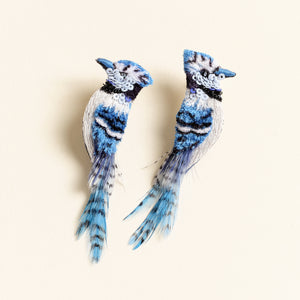 Blue Feather and Bead Embroidered Blue Jay Bird Earrings on Tan Background