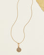 Gold Compass Pendant Necklace on Cream Background