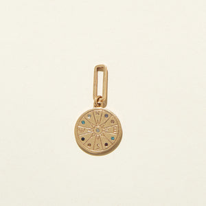 Gold Compass Charm with Multi-Colored Crystals on Cream Background