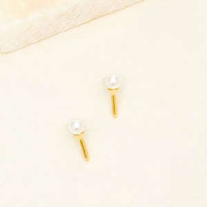Gold and Pearl Golf Tee Stud Earrings on Tan Background